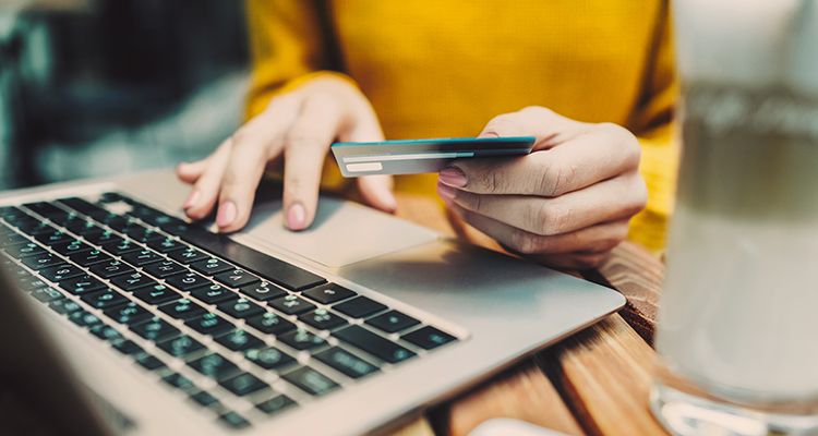 Woman's hands holding credit card and typing on keyboard on laptop