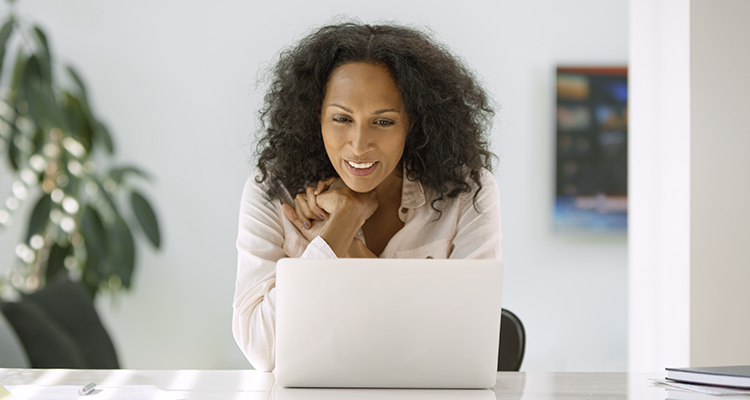 Mid adult woman using laptop at home.